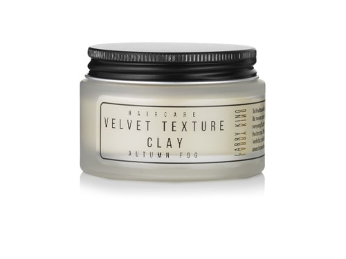 Ein Behälter für Haarpflege namens Velvet Texture Clay, Herbstnebel-Duft, mit schwarzem Deckel.