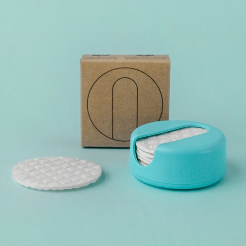 Ein blauer Pack mit Tüchern und eine Pappschachtel mit Symbol vor hellblauem Hintergrund.