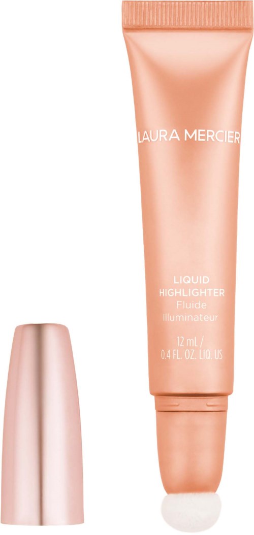 En persikfärgad tub med 'Laura Mercier'-märke och en liten vit hatt intill.