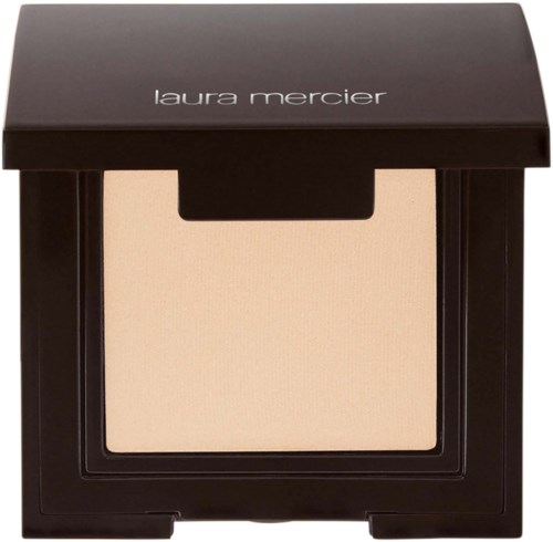 En Laura Mercier makeup-kompakt med beige puder inuti och ett svart skal.