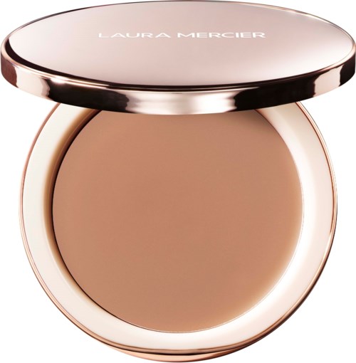 A compact with beige powder and a rose gold lid, labeled Laura Mercier, open showing the powder inside.