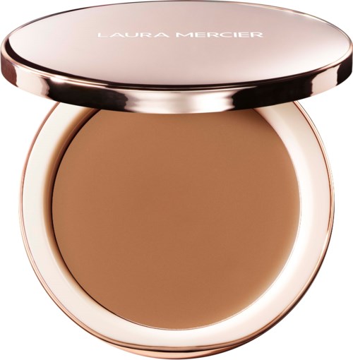A compact with a light brown pressed powder and a shiny rose gold case. Laura Mercier written on the lid.