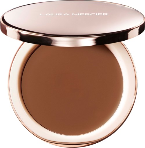 A compact with a round, open lid showing brown makeup inside, labeled Laura Mercier on the top.