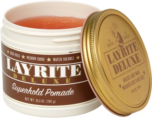A jar of Layrite Deluxe Superhold Pomade with a gold lid and reddish pomade inside.