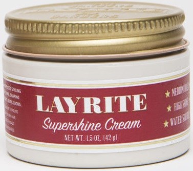 A white jar with a gold lid, labeled 'Layrite Supershine Cream,' indicating it is a hair styling product.