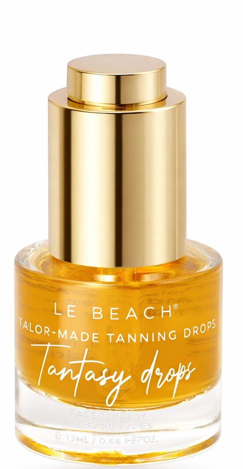A small glass bottle with golden cap and yellow liquid inside, labeled Le Beach tanning drops.