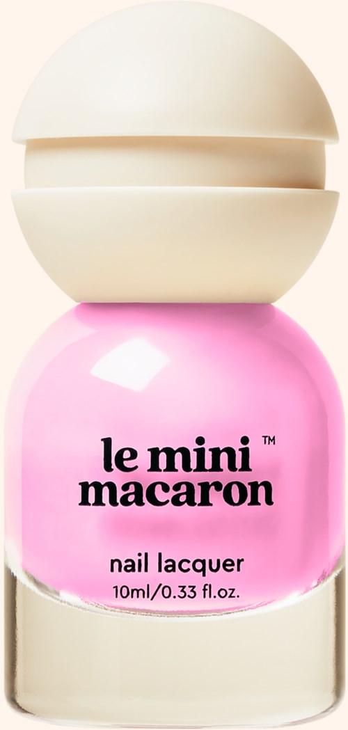 A pink nail polish bottle with a rounded white cap and the words 'le mini macaroon' on it.