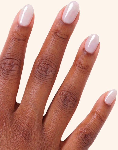 Four fingers with neatly painted white nails against a light background.