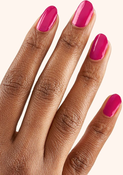 A hand with four fingers visible, nails painted bright pink, on a plain background.