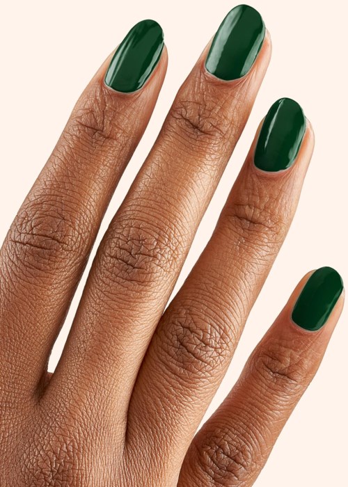 Close-up of a hand with dark green painted nails on a light background.