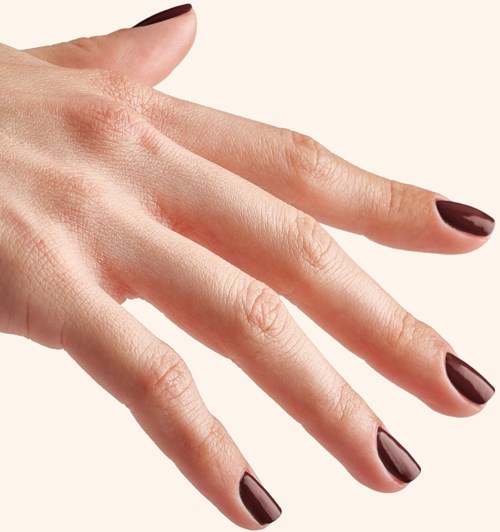A hand with well-manicured nails painted dark red or burgundy. The skin looks smooth and clean.