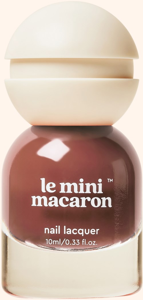 A small jar of nail lacquer with a round white cap and a label reading 'le mini macaron' in brown.