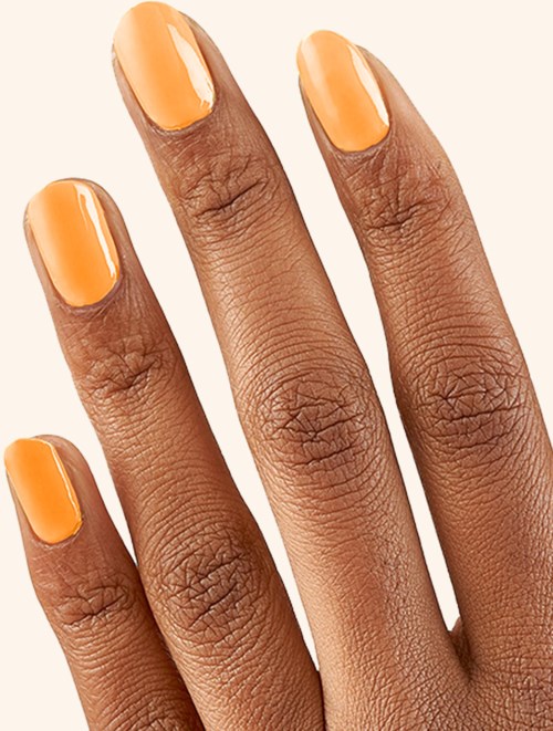 A hand with orange painted nails on a light background.