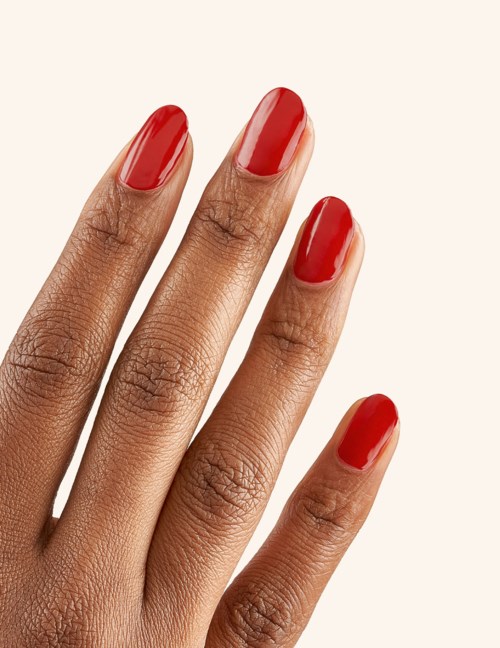 Hand with three fingers visible, painted nails red and well-groomed skin.