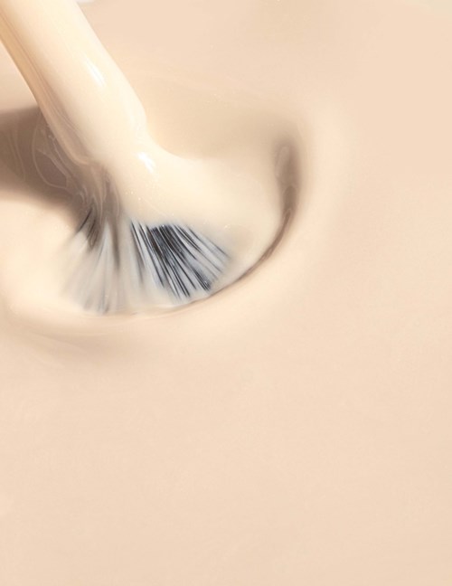 A makeup brush is applying makeup on a person's face.