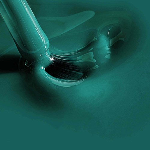 A teal liquid being poured from a container, creating a flowing, smooth surface.