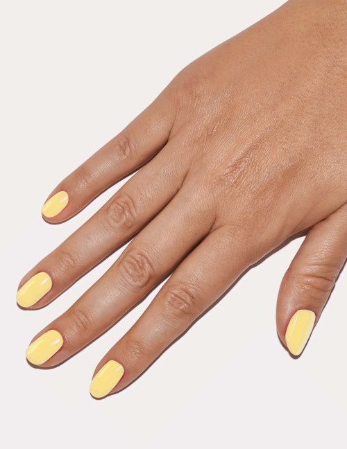 A hand with yellow painted nails against a plain background.