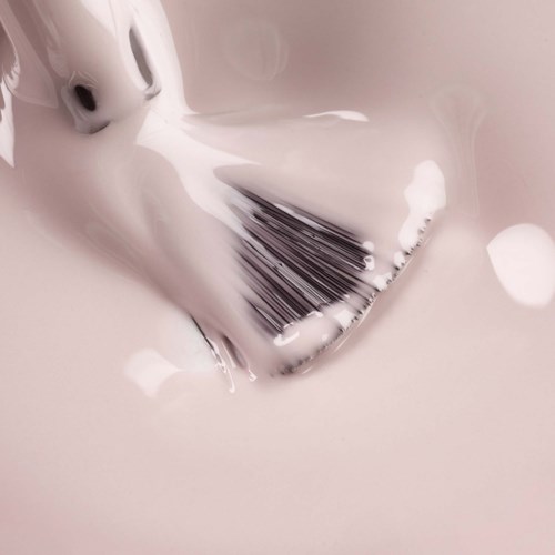 A barcode scanning device is submerged in milky liquid, with some liquid spilling around it.