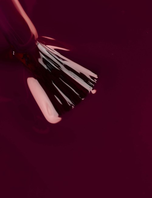 A black and white fan with multiple blades, held over a pink and black background.