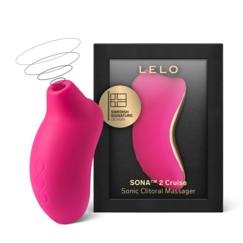 A pink, curved, vibrating massager with a black box and gold label, designed for intimate pleasure.