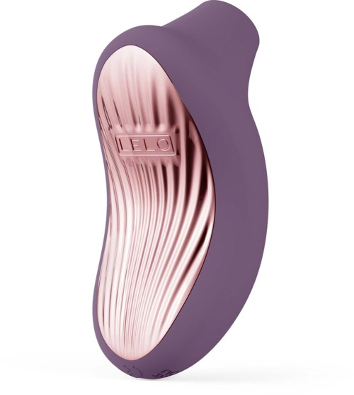A purple and pink facial cleansing brush with a curved shape and textured surface.