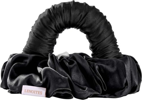 A black satin hair scrunchie with a fabric band, displayed on a plain background.