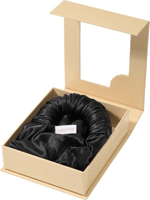 A black satin gift set inside a beige box with an open lid, looking elegant.