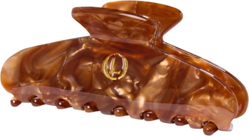 A large brown hair clip with a shiny, marbled finish and a small gold logo in the middle.