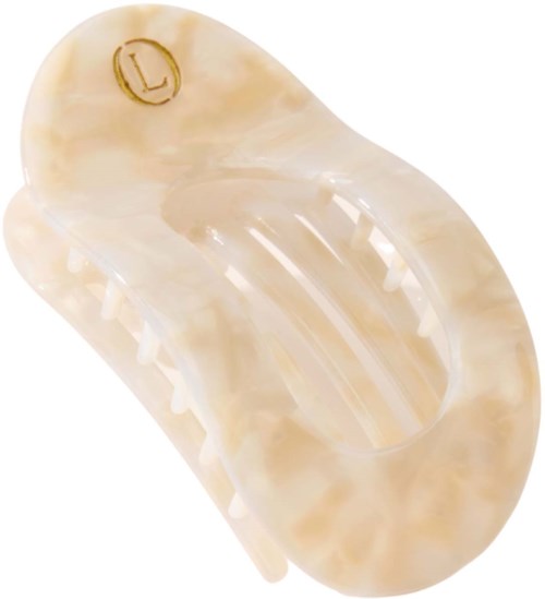 Een beige plastic haarspeld met een gouden letter L gegraveerd.