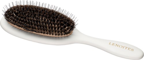 A white hairbrush with black bristles and a gold brand name. It has a curved handle.