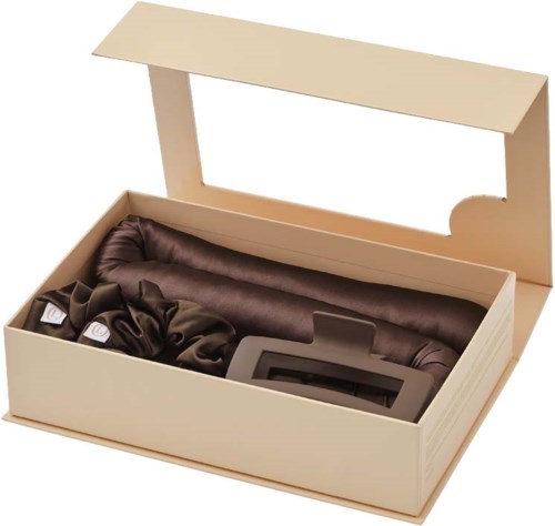 A gift box with a silk scarf, a small device, and other dark-colored fabric inside.