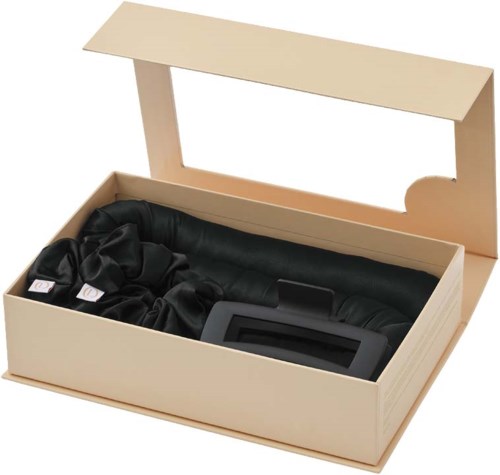 A beige box with a lid contains black silk hair ties and a black hairbrush.