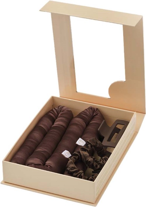 A beige box with a glass lid contains four rolled-up pairs of dark brown socks.