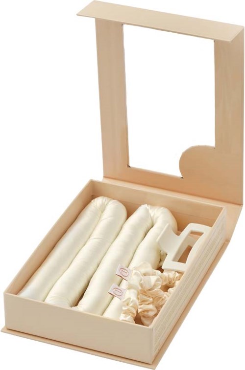 A wooden box with a mirror, containing four rolled-up cloths and some small decorative items.