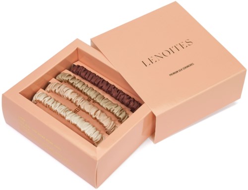 A pink box with four different colored meringue cookies inside, labeled "LENOIT" on the lid.