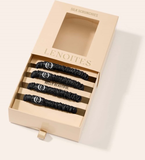 Four black silk hair scrunchies in a beige box, with one saying "Hello Beautiful" and another "Lento".