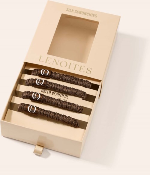 Box contains four chocolate-covered sticks labeled with messages, placed inside a cream box named "LENOITES".