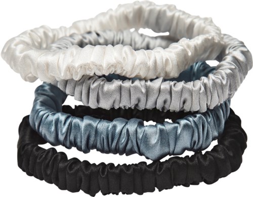 Four satin scrunchies in white, gray, blue, and black stacked together. They are elastic and gathered. Stylish hair accessories.