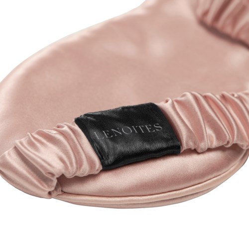 Eine rosa Satinbörse mit einem schwarzen Etikett, auf dem "LENOITES" steht.