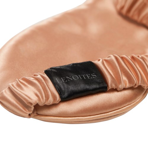 Eine pfirsichfarbige Satin-Clutch mit schwarzen Riemen, auf dem "LENOITES" steht.