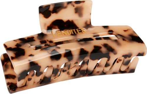 A large tortoiseshell-patterned hair clip with the words 'LE NOTES' written on it.
