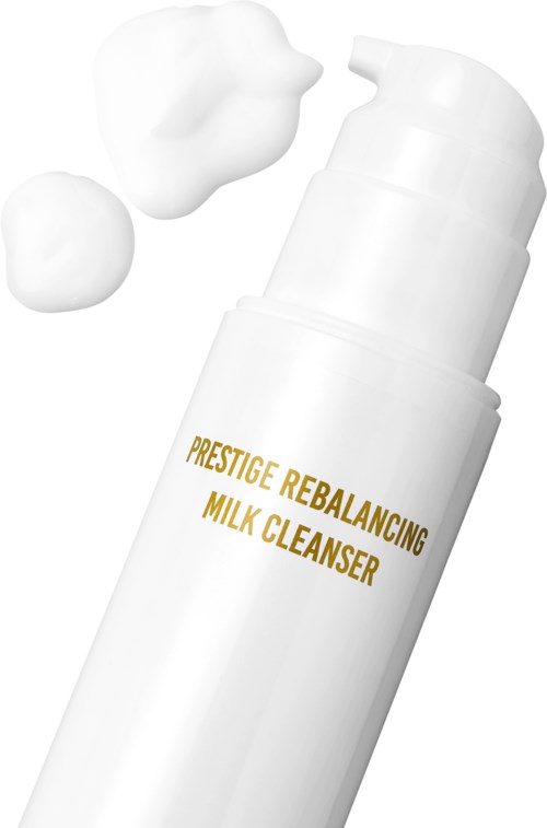 Witte fles met melk reiniger met schuim bovenop en twee dotten ernaast.