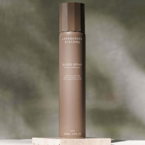 Ein langer, beige Sprühflasche mit braunem Deckel, beschriftet 'Lernberger Stafsing Gloss Spray' für Haare.