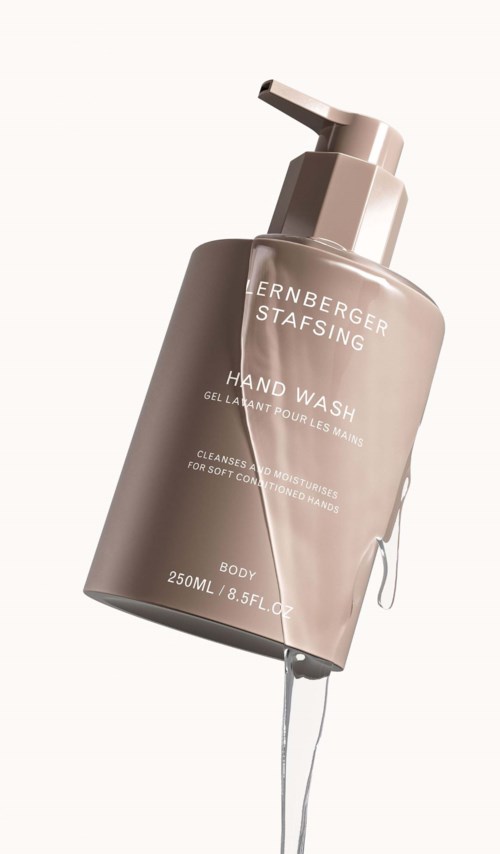 Beige Handseifendose mit Pumpe, beschriftet mit Marke und Anweisungen, steht aufrecht.