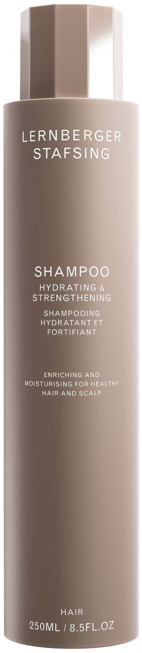 Eine lange, beige Flasche Shampoo mit weißen Texten, die es als feuchtigkeitsspendend und stärkend für Haare und Kopfhaut beschreibt.