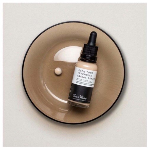 En serumflaske med dråpeteller i en beige skål med serum og en liten hvit pille.