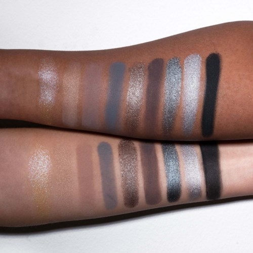 Zwei Arme zeigen Swatches verschiedener Lidschattenfarben, einschließlich Glitzer, Matt und Schimmer.