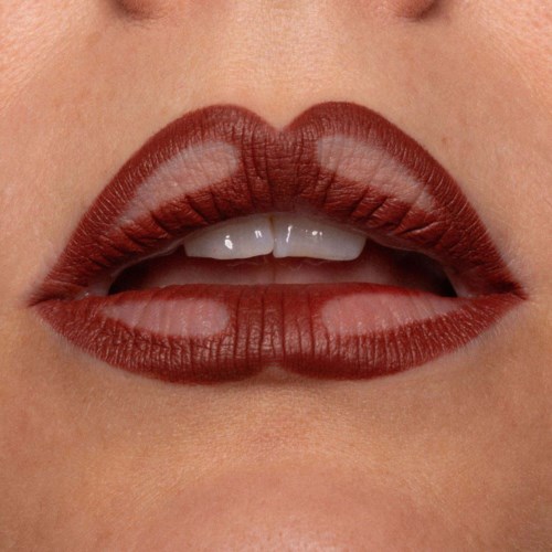 Close-up of lips with dark red lipstick, slightly parted showing teeth.