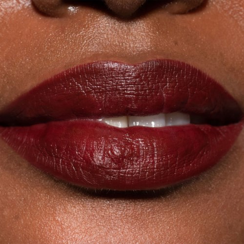 Nahaufnahme von Lippen mit dunkler roter Lippenstift und einem kleinen Spalt, der Zähne zeigt.