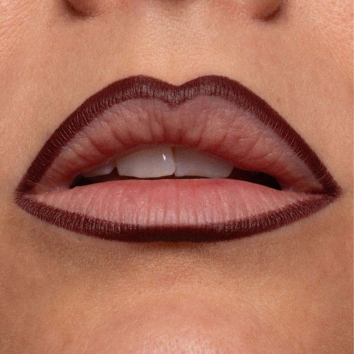 Close-up of lips with dark lipstick, slightly parted showing teeth and tongue.
